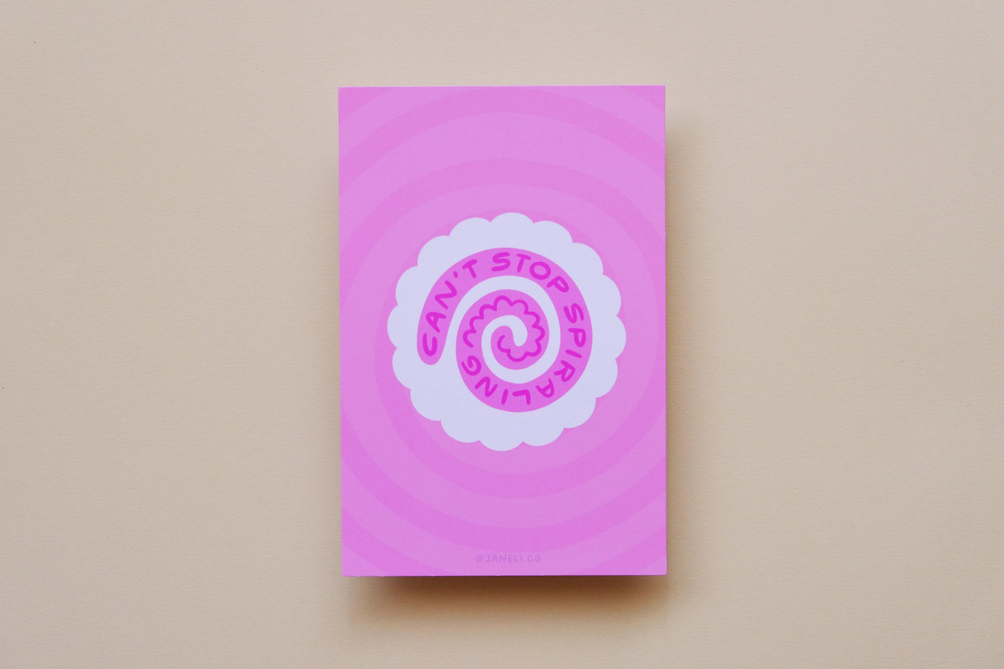 A JaneLi.Co mini print/postcard of a white fish cake with a pink spiral that says "Can't stop spiraling" over a pink background.