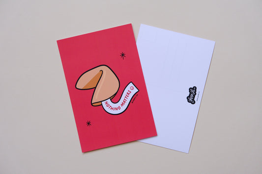 A JaneLi.Co mini print/postcard of a fortune cookie that says "Nothing Matters" and a back postcard side of the same print over a cream background.
