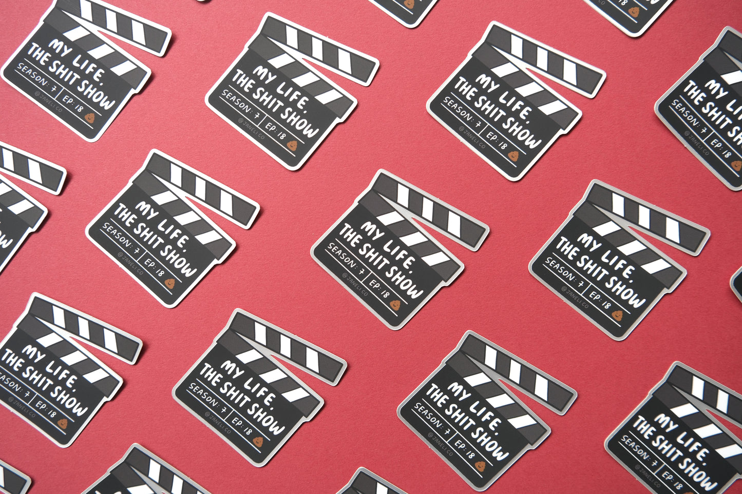 A grid of JaneLi.Co stickers of movie clappers that say "My life, the shit show" over a maroon background.
