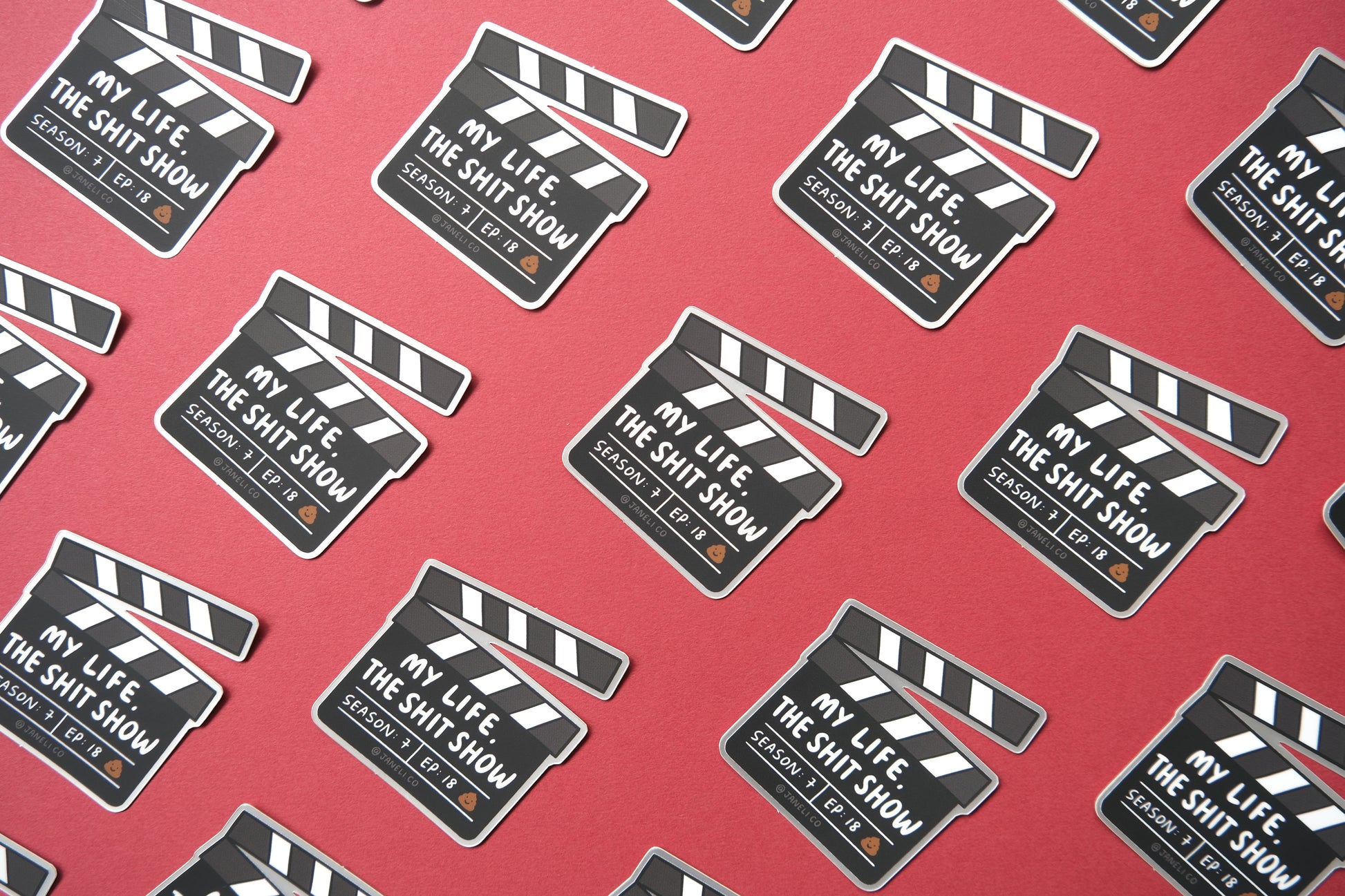 A grid of JaneLi.Co stickers of movie clappers that say "My life, the shit show" over a maroon background.