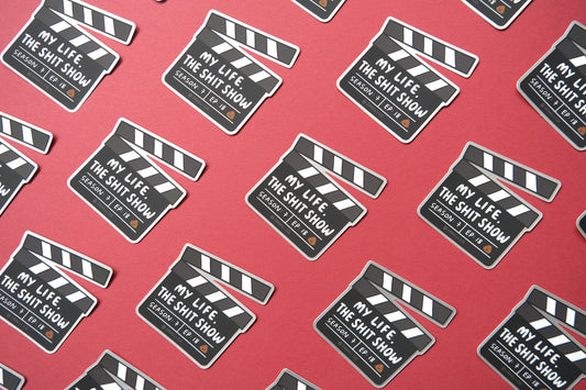 A grid of JaneLi.Co stickers of movie clappers that say "My life, the shit show" over a maroon background.