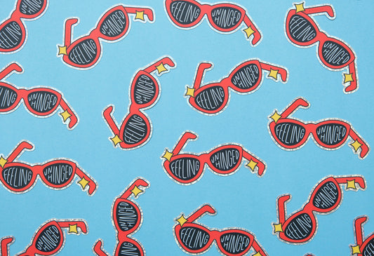 A grid of JaneLi.Co stickers of broken red sunglasses that say "Feeling Unhinged" over a blue background.