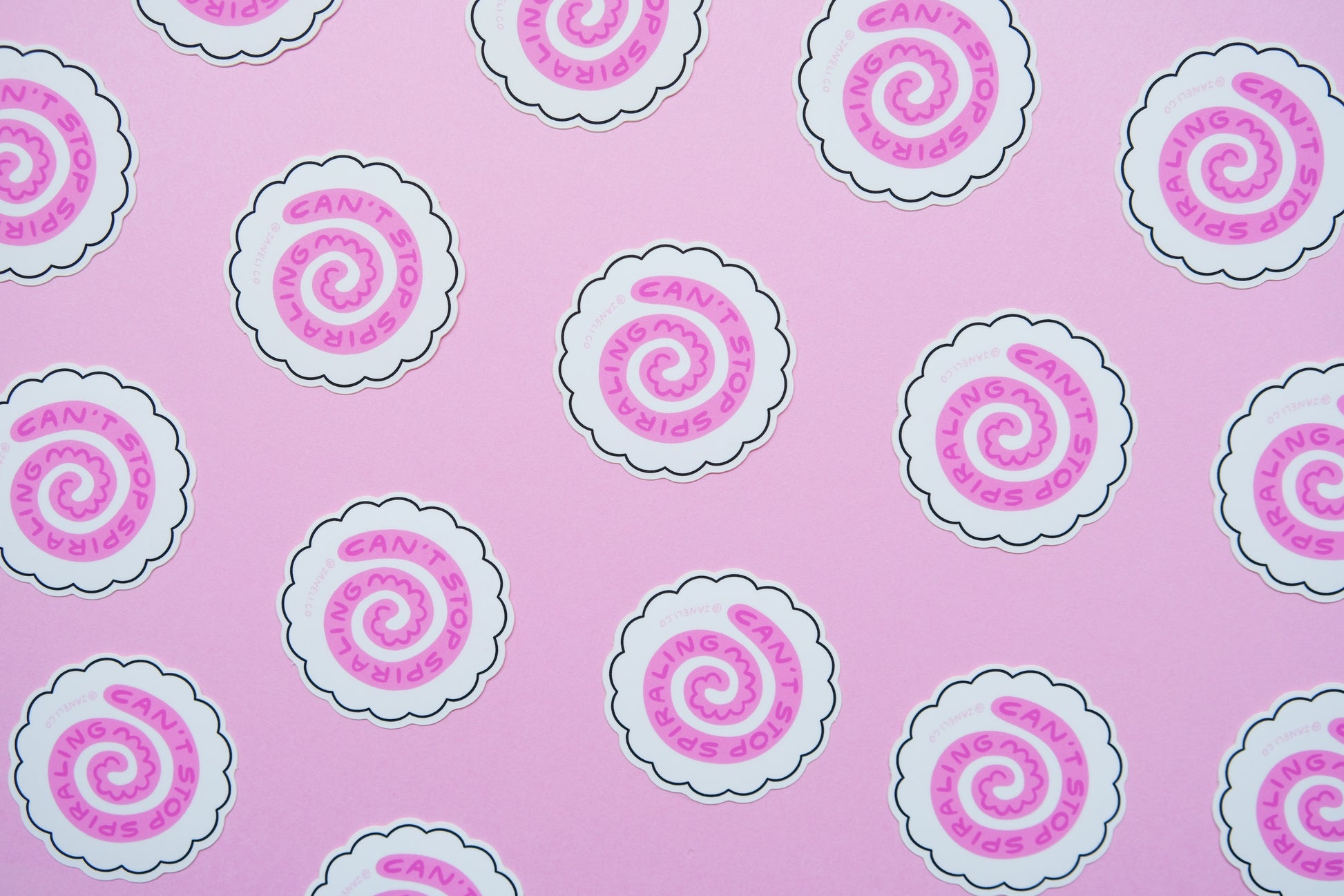 A grid of JaneLi.Co stickers of white fish cakes with pink swirls that say "Can't stop spiraling" over a pink background.