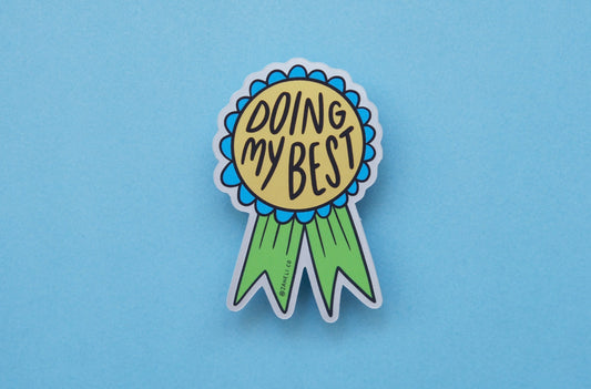 A JaneLi.Co sticker of a blue and green award ribbon that says "Doing My Best" over a blue background.