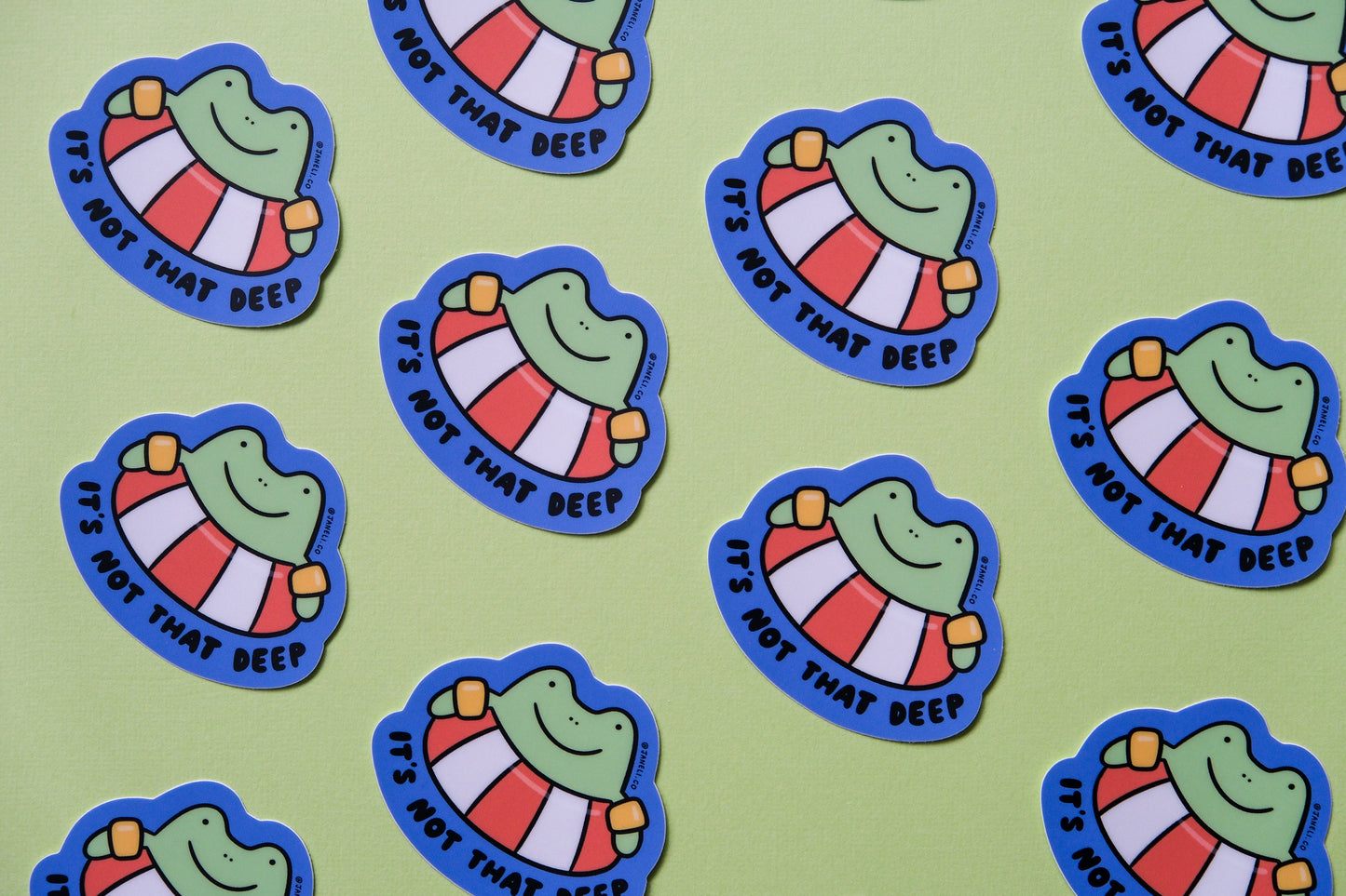 A grid of JaneLi.Co stickers of frogs floating in lifessaver tubes that say "It's not that deep" over a green background.