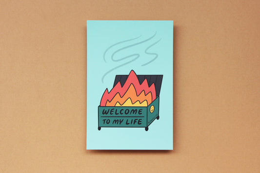 A JaneLi.Co mini print/postcard of a dumpster fire that says "Welcome to My Life" over a tan background.
