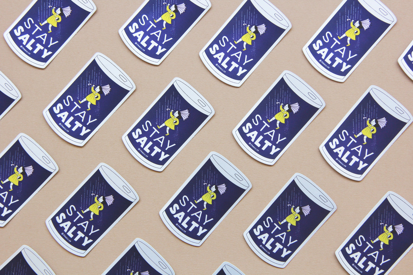 A grid of JaneLi.Co stickers that say "Stay Salty" in the shape of salt cans with angry salt girls holding umbrellas blow backwards from wind and rain over a navy blue background.