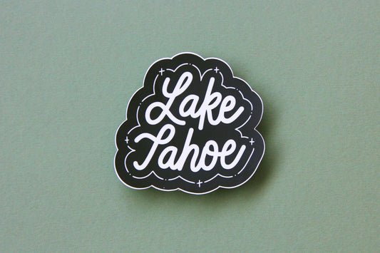 A black and white JaneLi.Co sticker that says "Lake Tahoe" in cursive lettering over a green background.