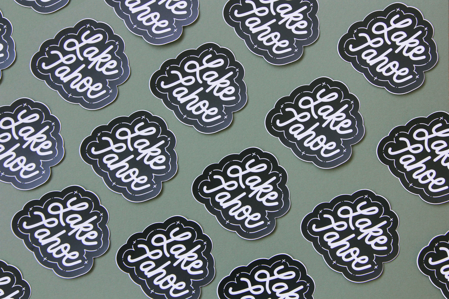 A grid of black and white JaneLi.Co stickers that say "Lake Tahoe" in cursive lettering over a green background.