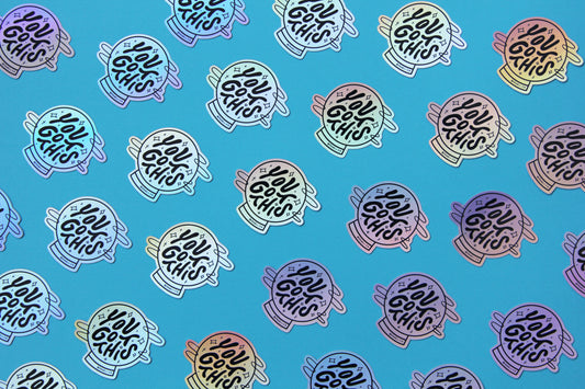 A grid of holographic JaneLi.Co stickers that say "You Got This" in a magic crystal ball over a blue background. 