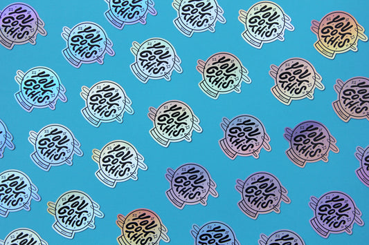 A grid of holographic JaneLi.Co stickers that say "You Got This" in a magic crystal ball over a blue background.