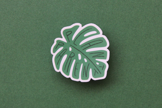 A green JaneLi.Co sticker that says "Plant Parent" in the shape of a monstera leaf over a green background.
