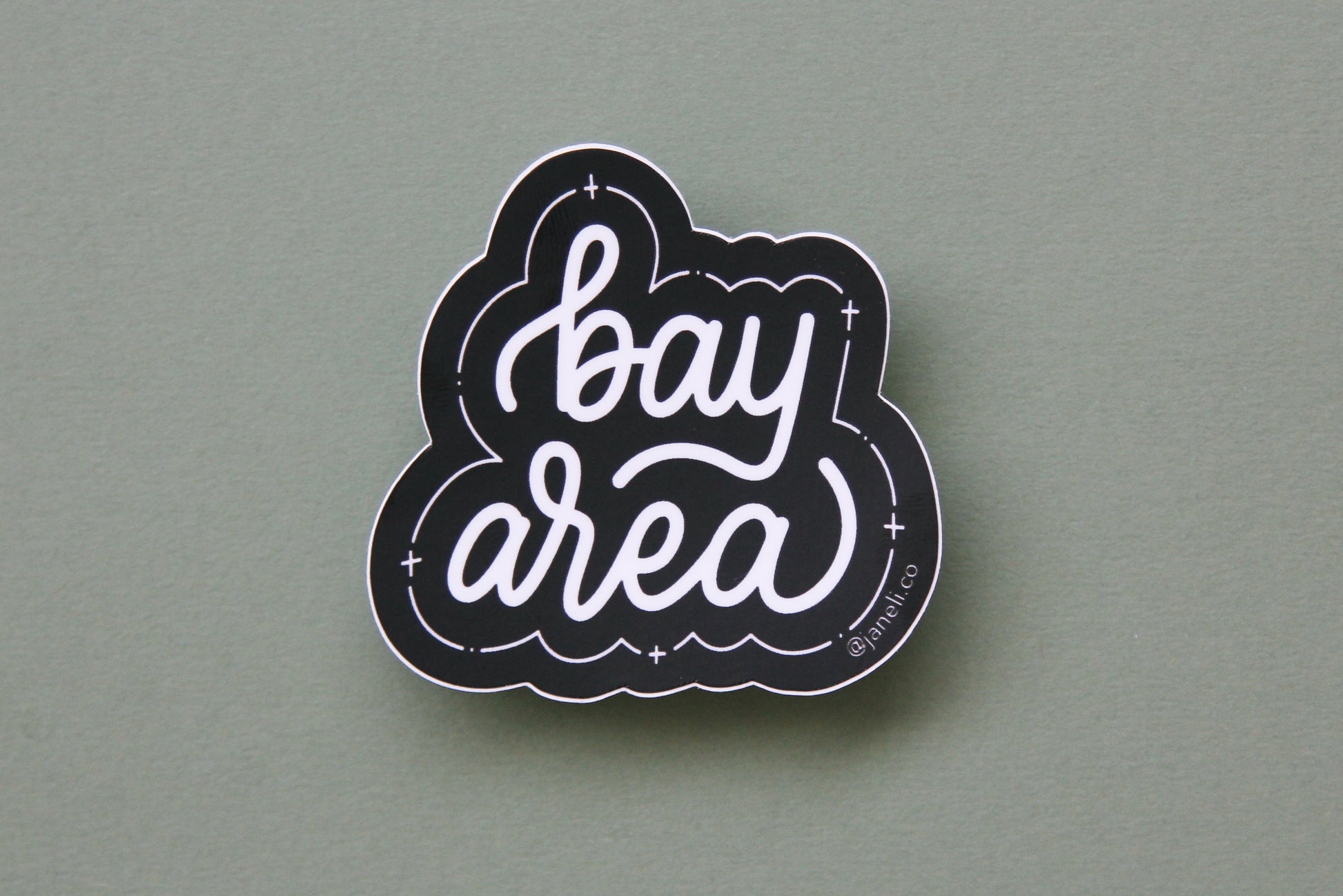 A black and white JaneLi.Co sticker that says "Bay Area" in cursive lettering over a green background.