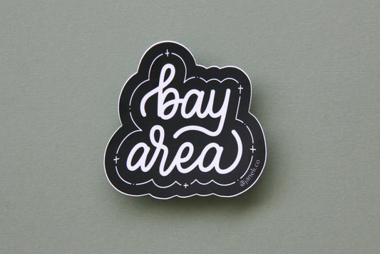 A black and white JaneLi.Co sticker that says "Bay Area" in cursive lettering over a green background.