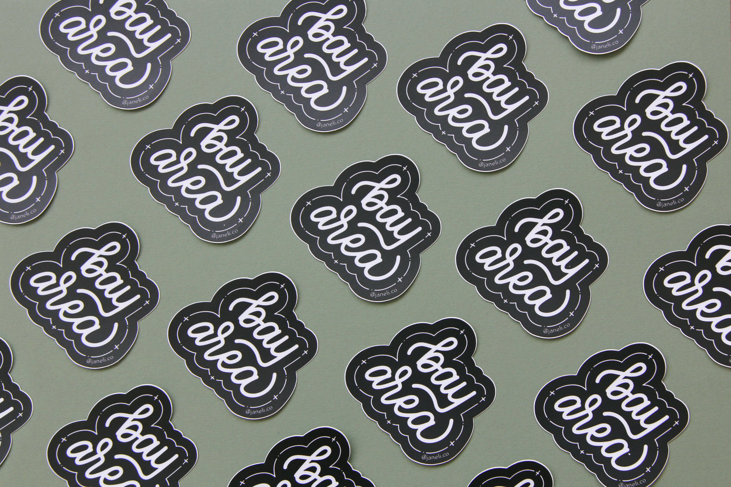 A grid of black and white JaneLi.Co stickers that say "Bay Area" in cursive lettering over a green background.