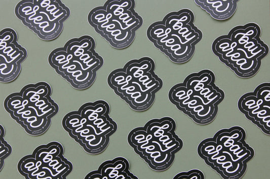 A grid of black and white JaneLi.Co stickers that say "Bay Area" in cursive lettering over a green background.