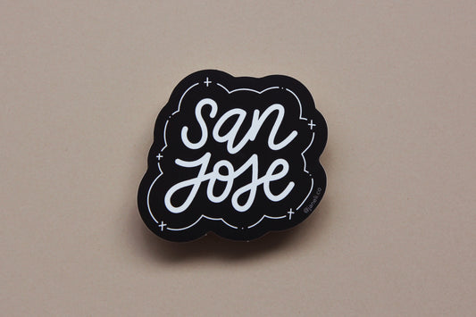 A black and white JaneLi.Co sticker that says "San Jose" in cursive lettering over a tan background. 