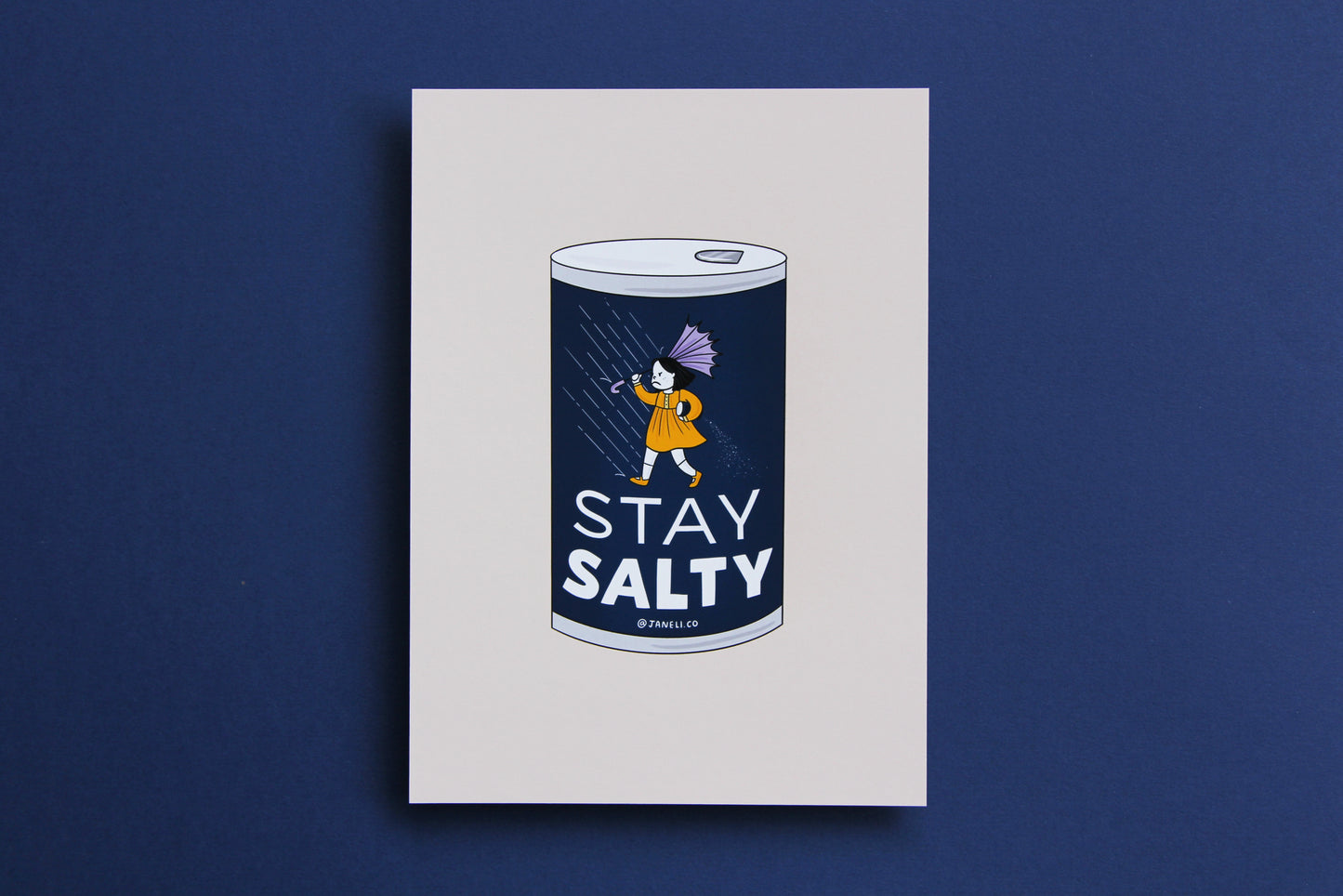 A JaneLi.Co print that shows a grumpy salt girl spilling a can of salt in the rain over a navy background.