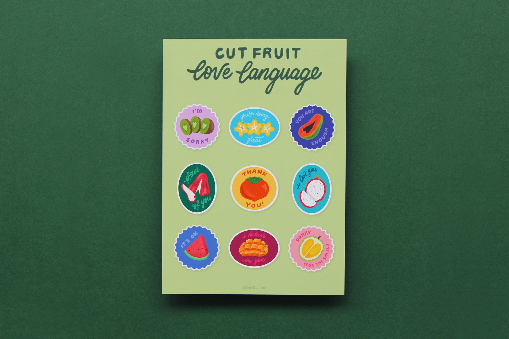A JaneLi.Co print that says "Cut Fruit Love Language" with 9 different fruit stickers with different messages like "I love you", "I'm sorry", and "I'm proud of you" over a green background.