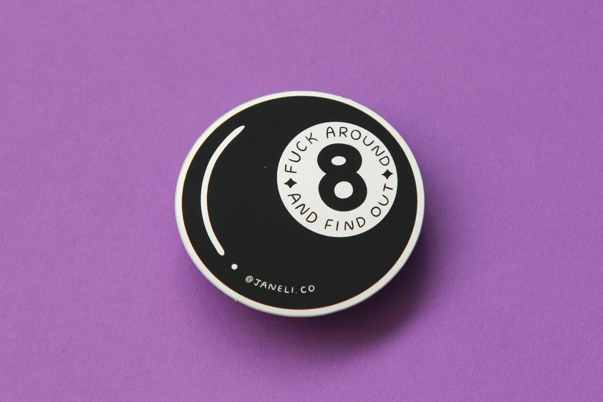 A JaneLi.Co sticker that says "Fuck aroudn and find out" in a magic 8 ball over a purple background.