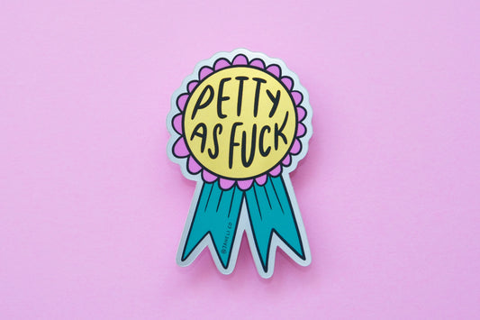 A JaneLi.Co sticker of a pink and teal award ribbon that says "Petty As Fuck" over a pink background.