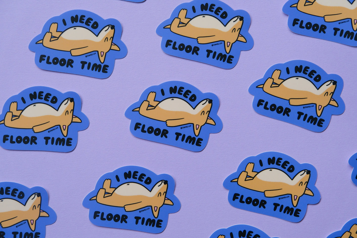 A grid of JaneLi.Co stickers of dogs lying on the floor that say "I need floor time" over a lavender background.