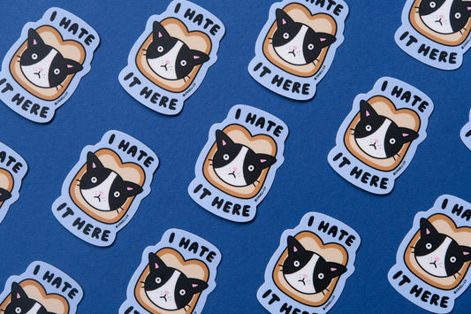 A grid of JaneLi.Co stickers of cast stuck in slices of bread that say "I hate it here" over a blue background.