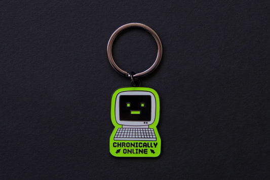 An enamel keychain of a retro computer that says "Chronically Online" over a black background.