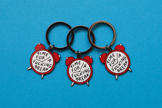 3 enamel keychains of alarm clocks that say "Time for a Fucking Break" over a blue background.
