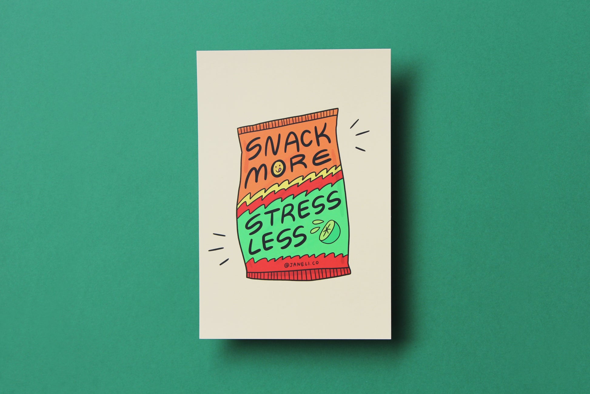 A JaneLi.Co mini print/postcard of a lime hot cheeto chip bag that says "Snack more stress less" over a green background.