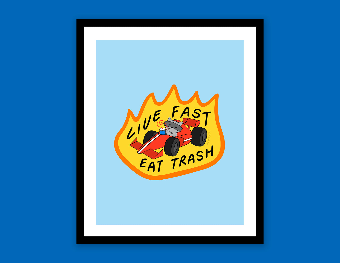 A digital mock of a framed JaneLi.Co print of a racoon driving a racecar while sipping a soda that says "Live Fast Eat Trash" over a blue background.