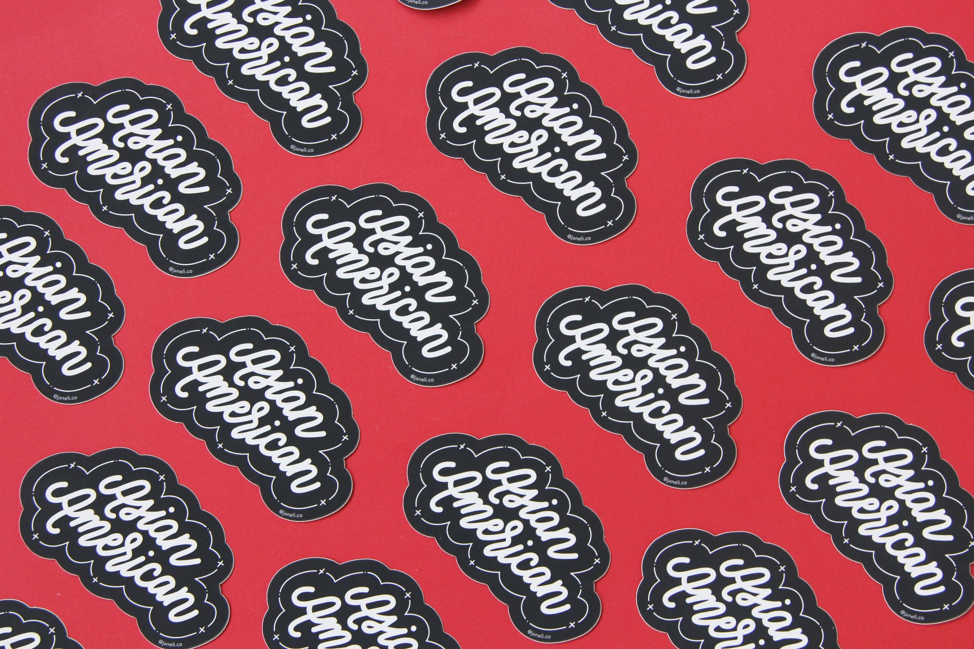 A grid of black and white JaneLi.Co stickers that say "Asian American" in cursive lettering over a red background.