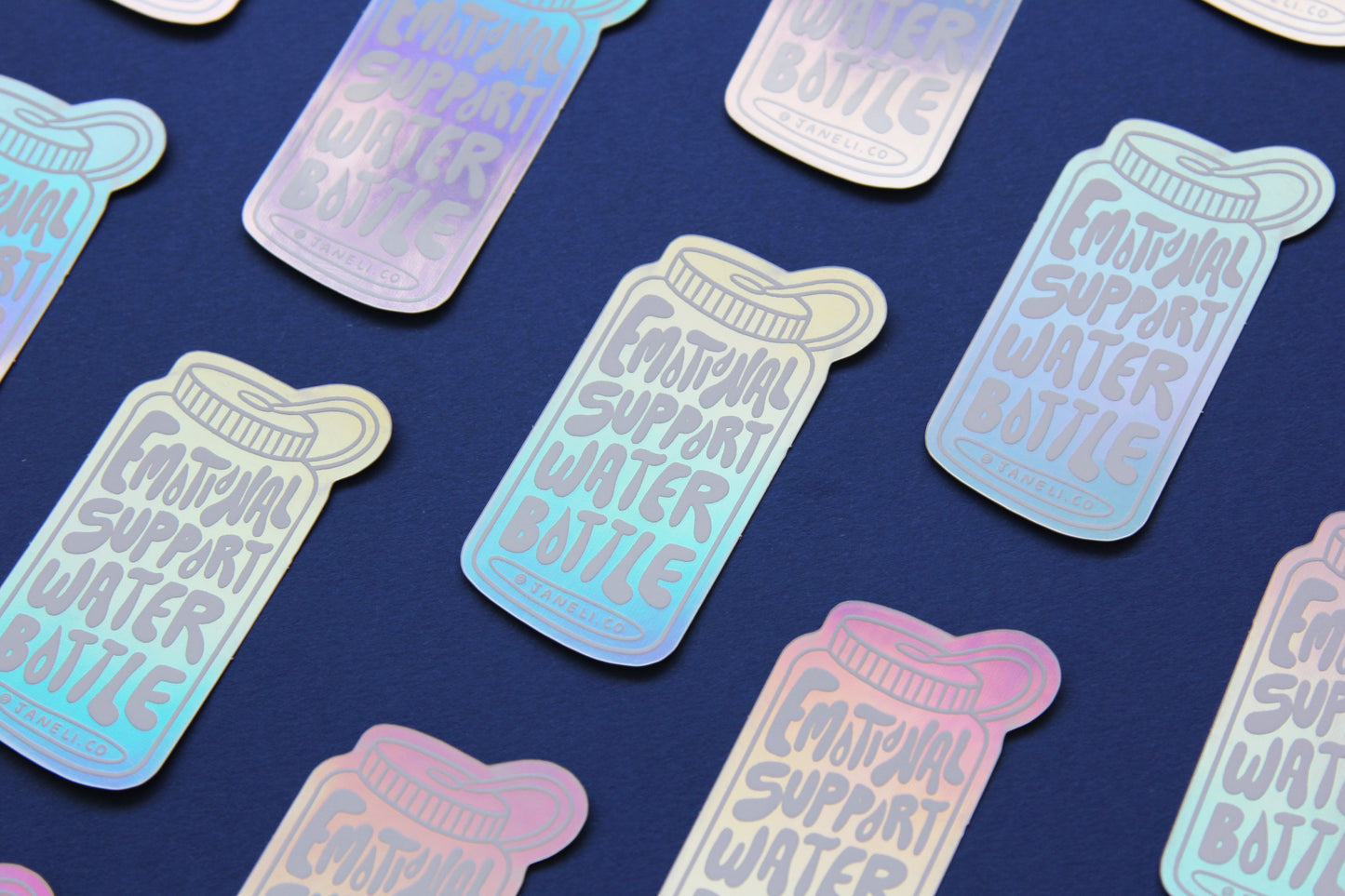 A grid of holographic JaneLi.Co stickers that say "Emotional Support Water Bottle" in the shape of a water bottle over a navy blue background.