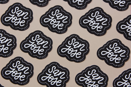 A grid of black and white JaneLi.Co stickers that say "San Jose" in cursive lettering over a tan background. 