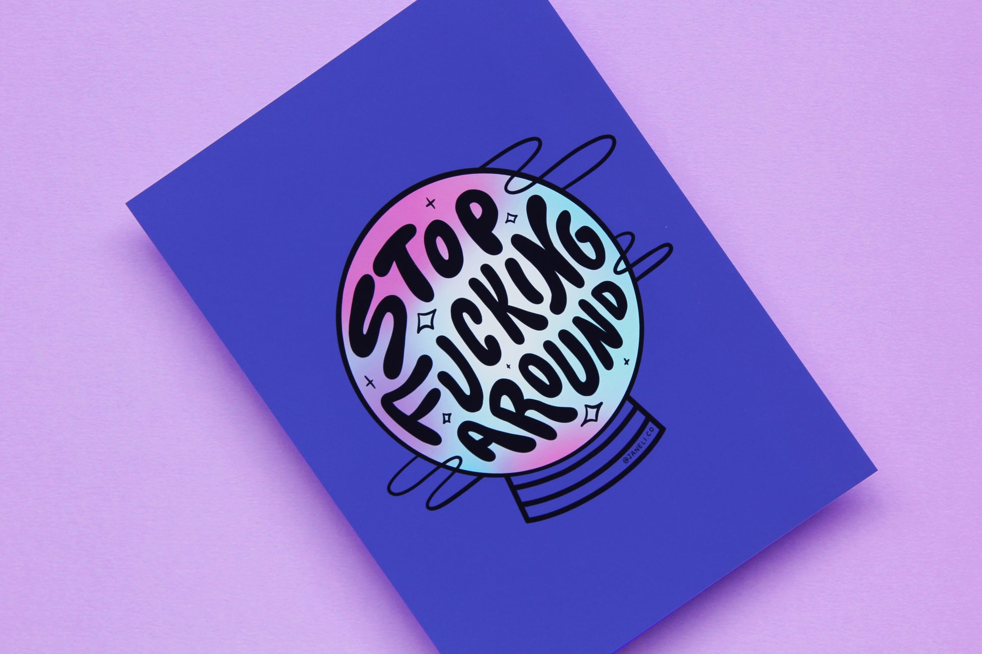 A close up of a JaneLi.Co print that says "Stop Fucking Around" in the shape of a magic crystal ball over a purple background.