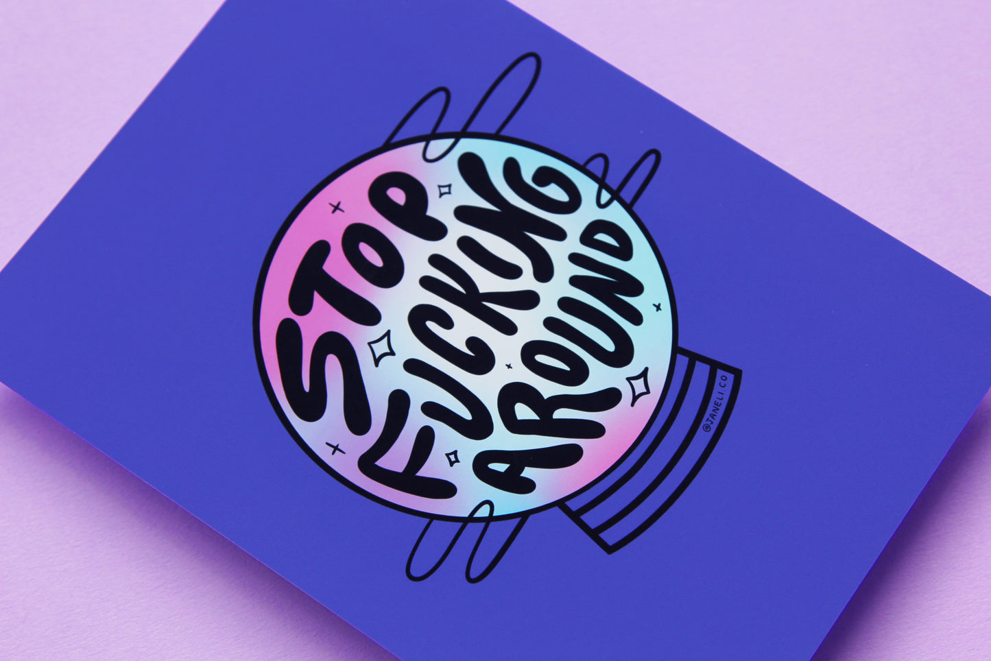 A close up of a JaneLi.Co print that says "Stop Fucking Around" in the shape of a magic crystal ball over a purple background.