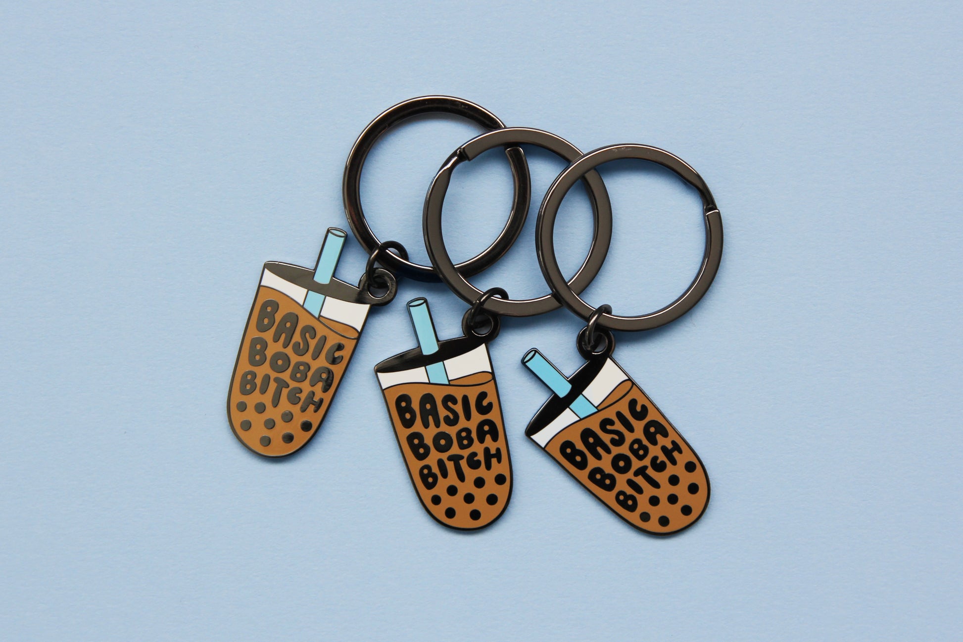 3 enamel keychains showing a cup of boba that says "Basic Boba Bitch" with a blue straw over a blue background.